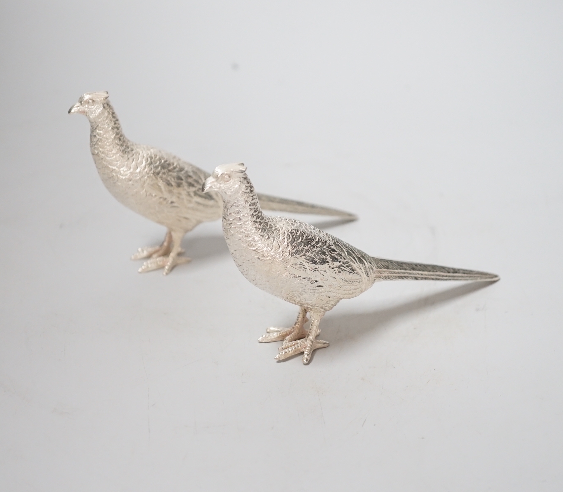 A pair of Elizabeth II silver model free-standing pheasants, by Albert Edward Jones, London, 1973, length 16cm, 9.6oz.